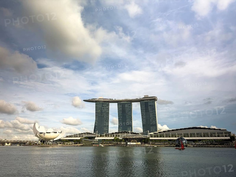 Captivating view of Marina Bay Sands hotel and ArtScience Museum against a cloudy sky in Singapore, showcasing modern architecture and a serene waterfront