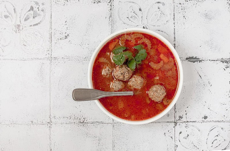Romanian soup with meatballs, vegetable soup with meatballs, tiled table, homemade, no people