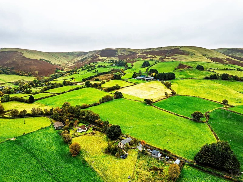 Autumn colours of Farms over River Wye and Road A470 from a drone, Llanidloes, Powys, Montgomeryshire, Wales, UK