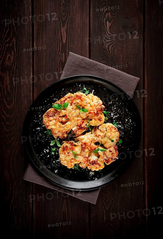 Steak, cauliflower, with cheese, spices, homemade, on a wooden table, dark background, close-up, top view, selective focus, no people