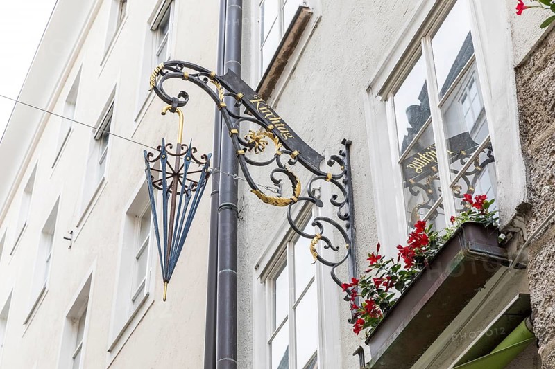 Famous Getreidegasse with umbrella as an advertising figure as a reference to the craftsman, old town of Salzburg, Austria