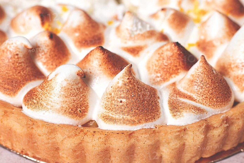 Lemon meringue cake, golden brown, toasted, on a light table, no people