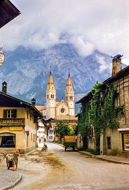Village street with historic buildings leading to the parish church, Telfs, Tyrol, Austria, Europe 1950s