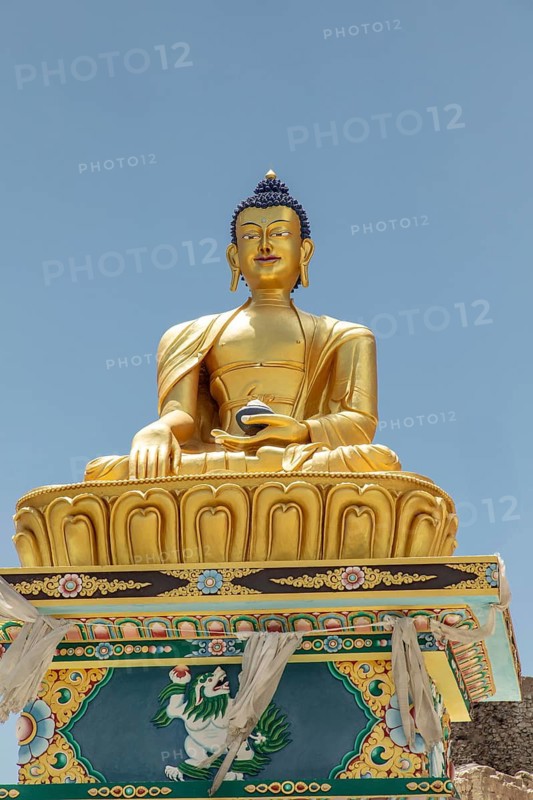 Majestic golden Buddha statue in Charasa, Nubra Valley, India, set against a clear blue sky. Exquisite detail and vibrant colors enhance the serene and spiritual atmosphere