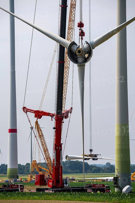 Dismantling of a wind power plant in a wind farm near Issum, 9 older wind turbines from the manufacturer Enercon (model series E-58), front, blades being dismantled, were in operation for over two decades, will be replaced by a total of four Enercon E-160 turbines, rear, assembly of the first blade, with a total output of 22 megawatts, Lower Rhine, North Rhine-Westphalia, Germany