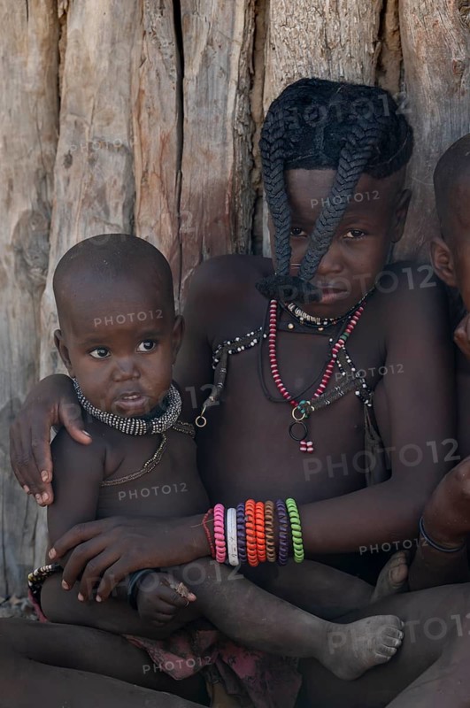 Himba girl with forward braided plaits with baby, near Opuwo, Kaokoveld, Kunene, Namibia