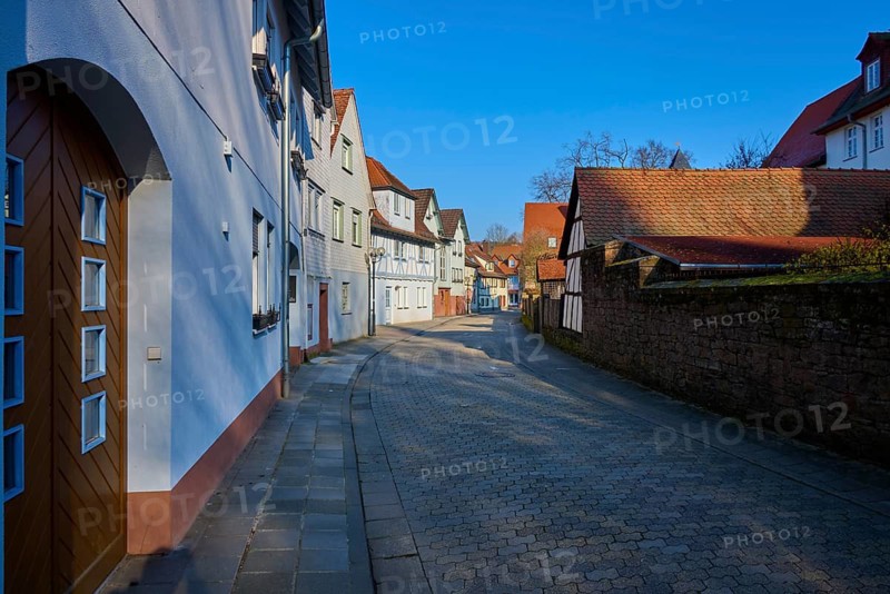 Small street with half-timbered houses under blue sky in quiet village atmosphere, Am Schlossgraben, Erbach, Odenwald, Hesse, Germany
