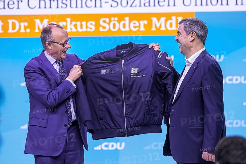 38th Federal Party Congress of the CDU of Germany in Stuttgart. Greetings from Markus Söder, party leader of the sister party CSU and Minister-President of the Free State of Bavaria. Federal Chancellor Friedrich Merz hands over an esa astronaut jacket to the guest speaker because of Söder's space visions. He is also an avowed fan of the cult film Star Trek. Stuttgart, Baden-Württemberg, Germany