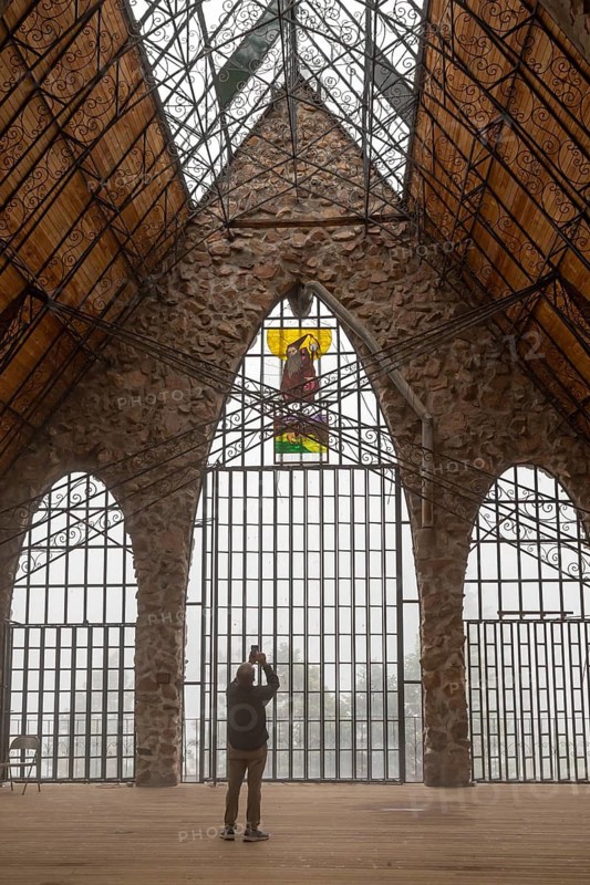 Rye, Colorado, A visitor photographs the Bishop Castle on a foggy morning. The Castle is an elaborate stone and metal structure and roadside attraction. It is being built by Jim Bishop in the mountains of San Isabel National Forest