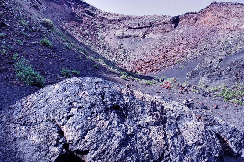 Partial view of Caldera de los Cuervos (El Cuervo volcano) with sparse vegetation and rocks, Tinajo Lanzarote