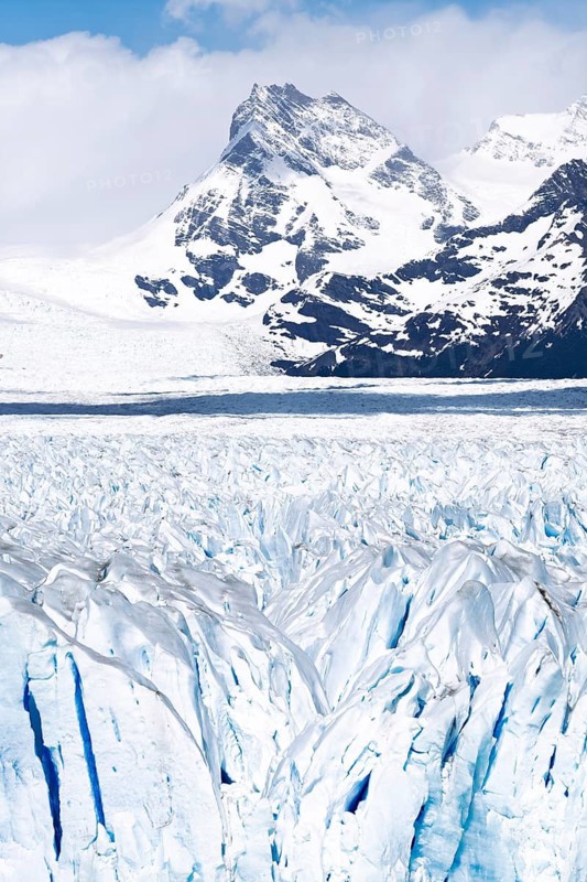 Perito Moreno glacier with rugged ice surface and blue crevasses, snow-capped Andean peaks in the background, Los Glaciares National Park, Santa Cruz Province, Patagonia, Argentina