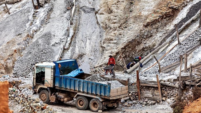 Truck and workers in a steep quarry loading rubble, The silver mines of Potosi on Cerro Rico in Bolivia