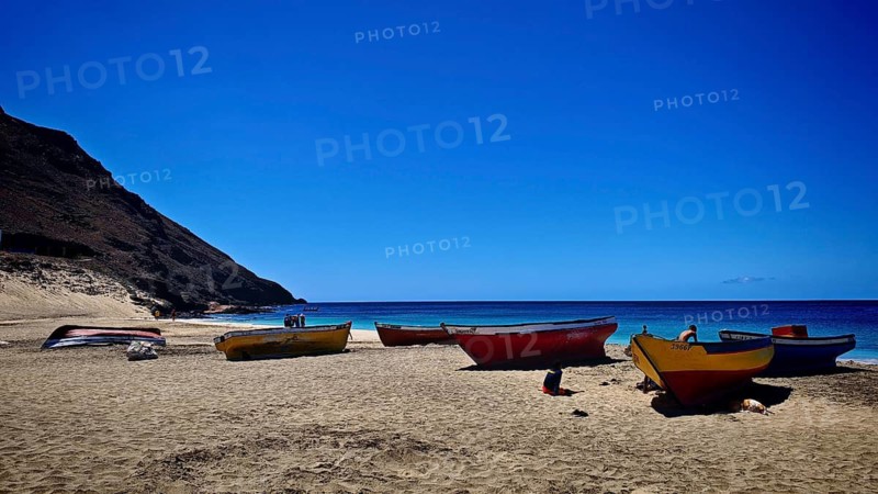 Colourful fishing boats lie on a sandy beach against a deep blue sea and clear sky backdrop, hiking, Sao Pedro, Sao Vicente, Cabo Verde, Cape Verde, Cape Verde