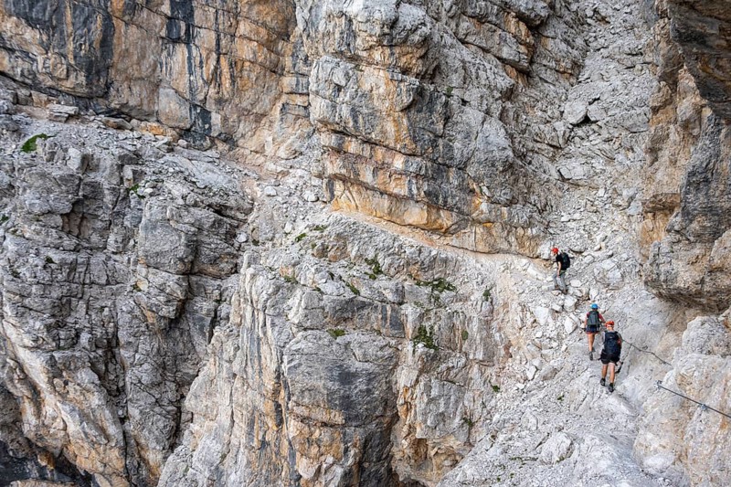 Three hikers on the Via Ferrate Benini via ferrata on a cliff, Brenta Mountains, Parco Naturale Brenta-Adamello, Trentino, Italy