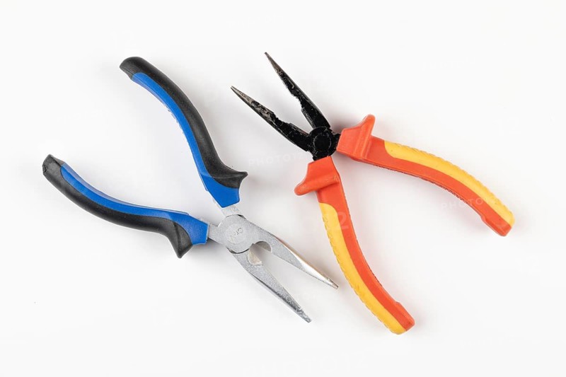 Two pliers with colorful handles, one blue, black others red, orange on a white background