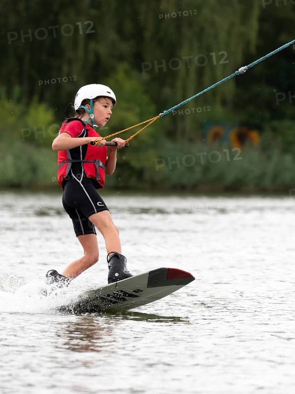 Boy or girl, water sports, wakeboard ride, red life jacket, water skiing in the wake park