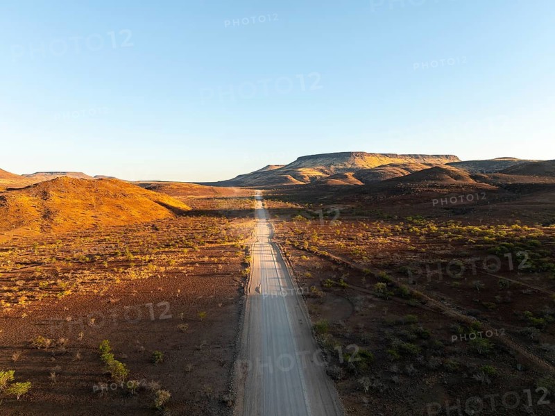 Aerial view, infinite space, straight road leads through dry desert landscape, hills in Damaraland, Namibia