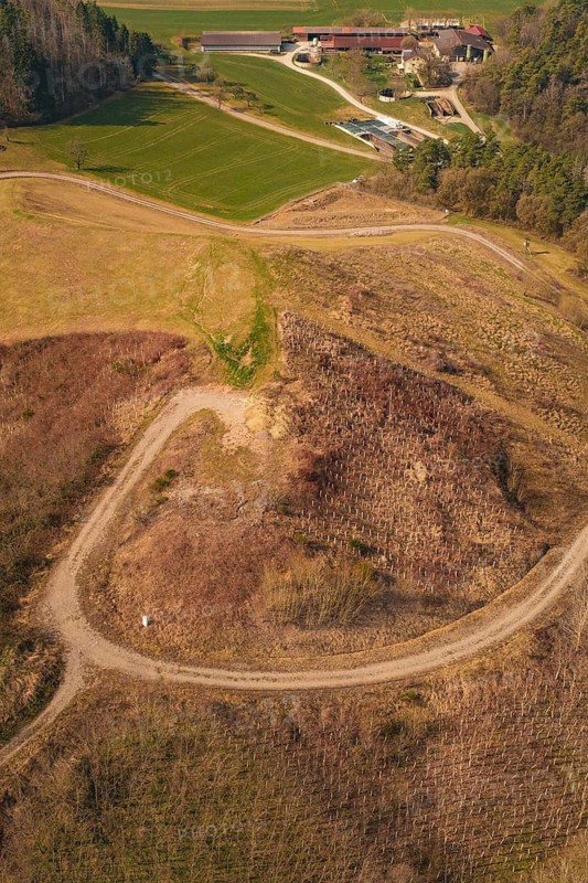 Aerial view of a rural landscape with hills, a field and a farm in warm autumn light, old deposit in front of PV Bau, Lindenrain, Calw, Germany