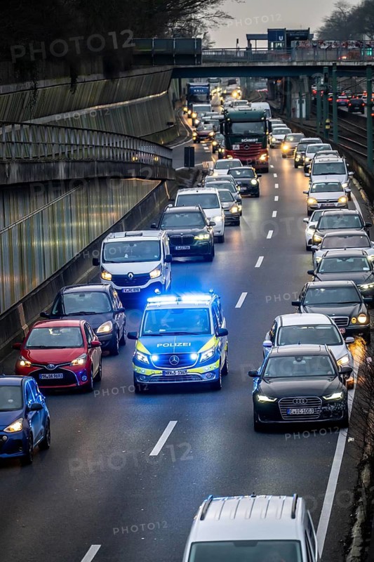 Traffic jam on the A40 motorway, emergency lane, vehicles on the left and right, police patrol car with flashing blue lights and siren, Essen, North Rhine-Westphalia, Germany