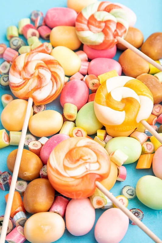 Various caramel candies on blue pastel background. close up, side view