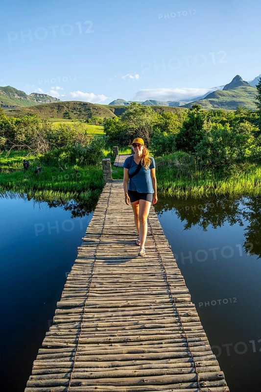 Young tourist on a jetty by a lake, Royal Natal National Park, Drakensberg Mountains south, Kwa Zulu Natal, South Africa