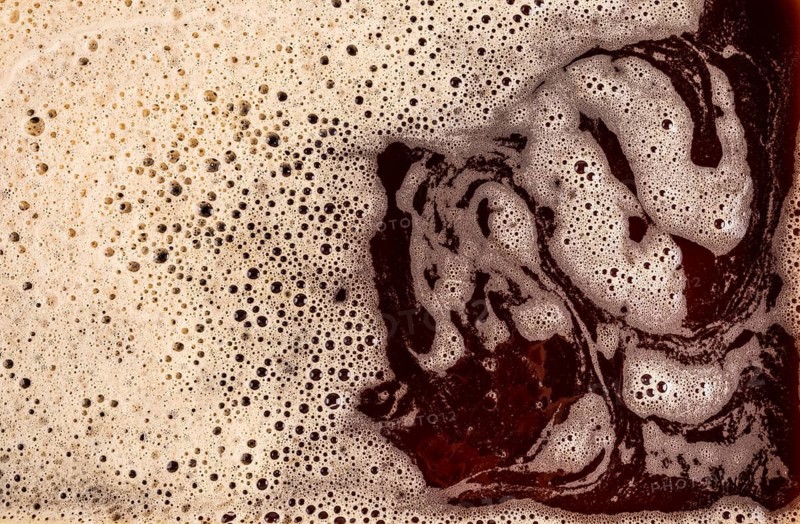 A detailed macro shot showcasing the rich texture of foamy coffee, highlighting its bubbly structure and creamy surface. Ideal for beverage, texture, and background concepts