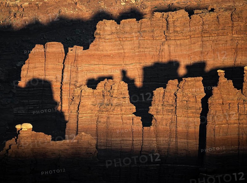 Shadows cast over the rugged rock formations in Canyonlands National Park, Utah, create a dramatic contrast of light and texture, highlighting the natural beauty of the landscape