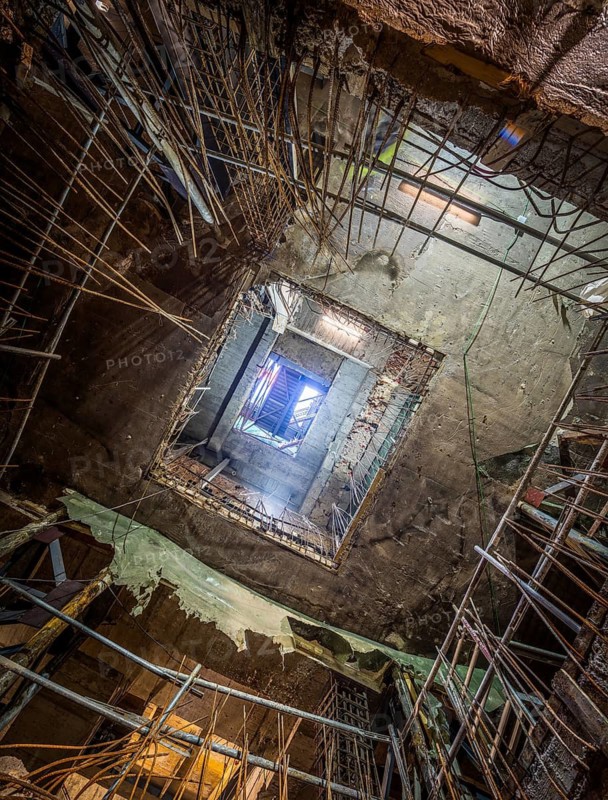View of a building under construction, showcasing exposed frameworks, steel reinforcements, and raw concrete. Captures the essence of architectural development in progress