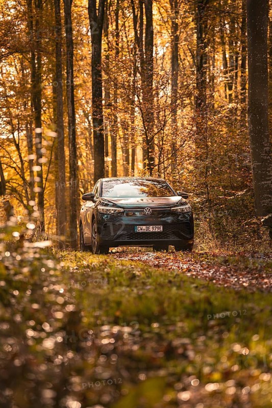 Car in a quiet autumn forest, surrounded by glowing leaves and warm light, electric car VW ID5, Gechingen, Black Forest, Germany