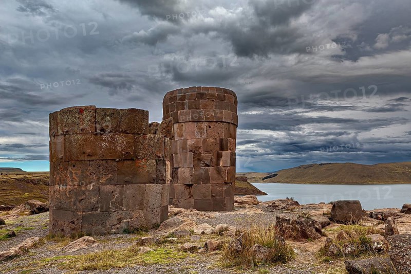 Two old stone towers on a lake under a dramatic sky, The Chullpas of Sillustani near Puno in Peru