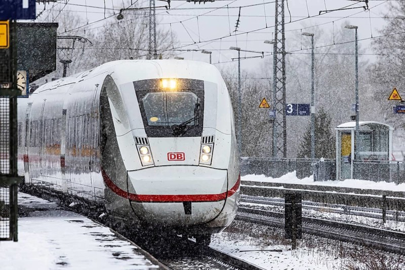 ICE traveling through a winter landscape in snowfall. A train on the line in the Deutsche Bahn Amstetten rail network, Baden-Württemberg, Germany