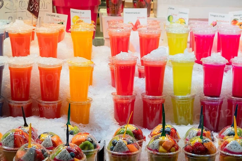 Smoothies and plastic fruit containers at La Boqueria market in Barcelona, Spain