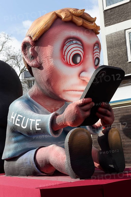 Boy staring at cell phone, motive car for youthful social media addiction, social media ban, theme car by wagon maker Jacques Tilly, Düsseldorf Rose Monday train, Düsseldorf, North Rhine-Westphalia, Germany