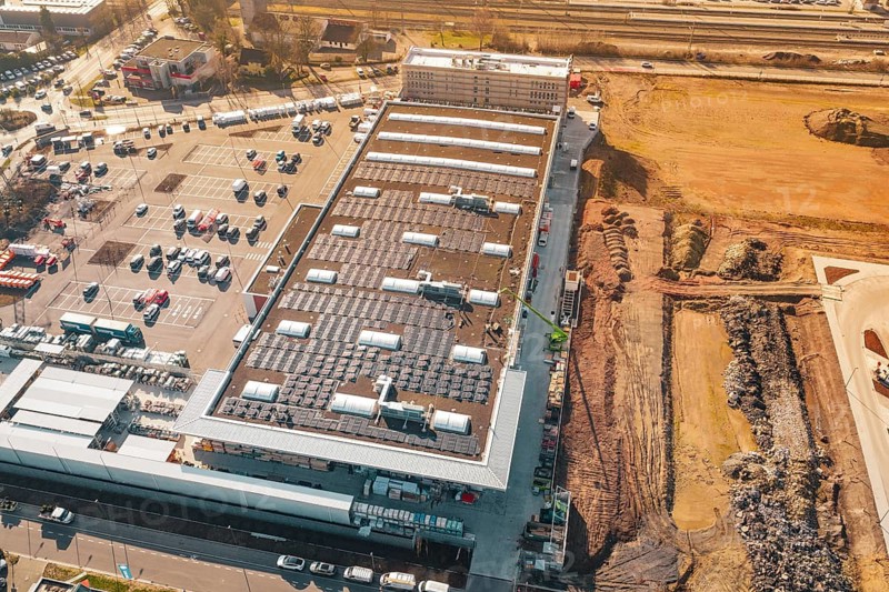 Aerial view of a large building with solar panels, surrounded by parking spaces and open spaces, PV Bau Auf OBI Bau Markt, Mühlacker, Enzkreis, Germany