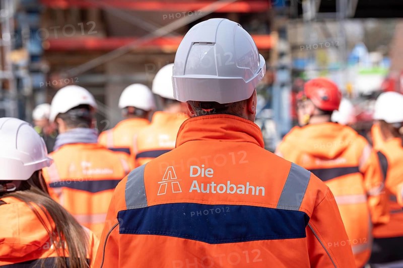 Autobahn GmbH employees wearing glowing protective clothing and safety helmet, on a construction site on the A516 motorway, Oberhausen, North Rhine-Westphalia, Germany