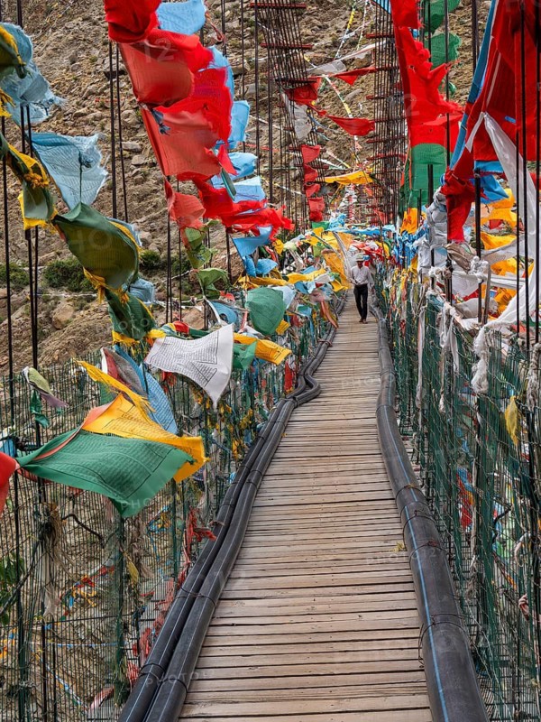 Suspension bridge with prayer flags, highlands of Tibet, China