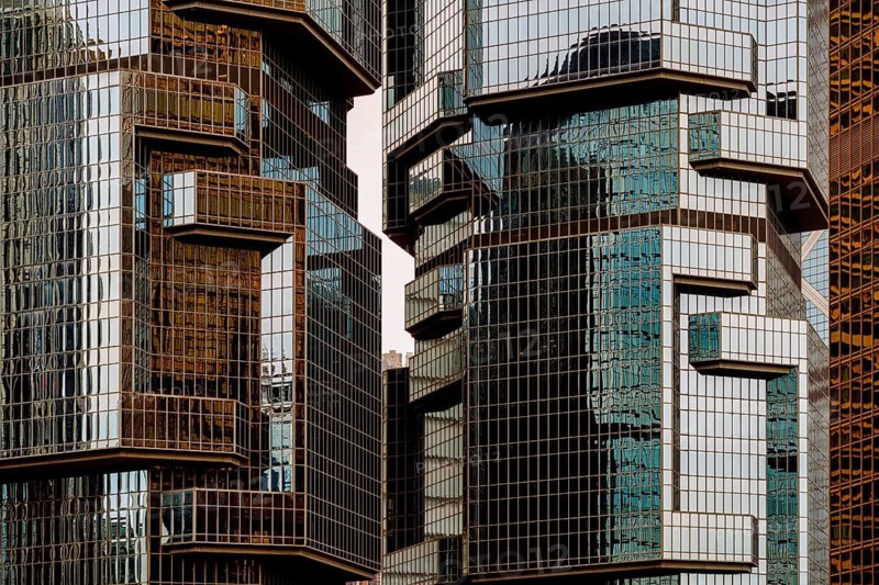 Cropped view of contemporary glass and steel buildings reflecting sunlight in the bustling city of Hong Kong, showcasing modern architecture and urban texture