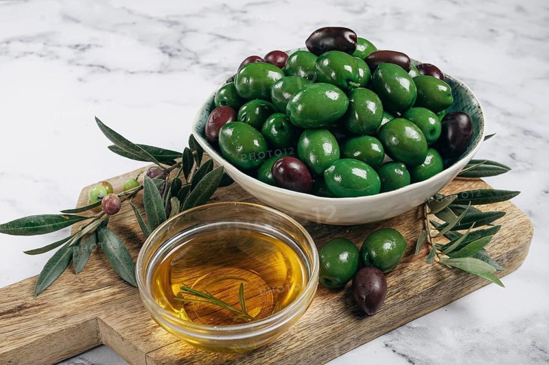 Chalkidiki olives, classic Greek green olives, in a bowl on a cutting board, top view, without people