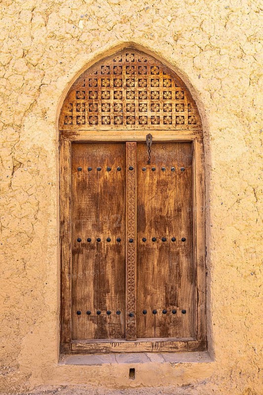 Decorated round arch entrance door in the largest preserved mud town in Oman, Al Bilaad, Al Bilaad Historical Village, Arabian Peninsula, Sultanate of Oman