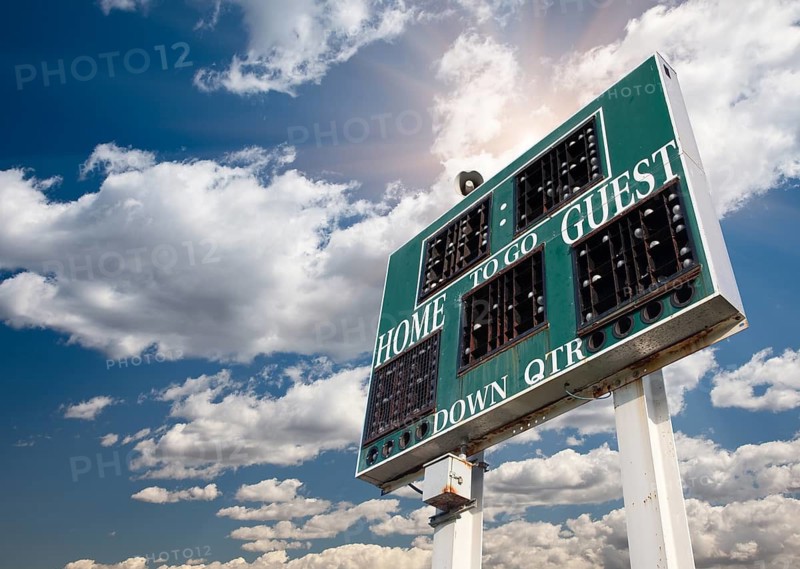 HIgh School Score Board on a Dramatic Blue Sky with Clouds and Sun Rays