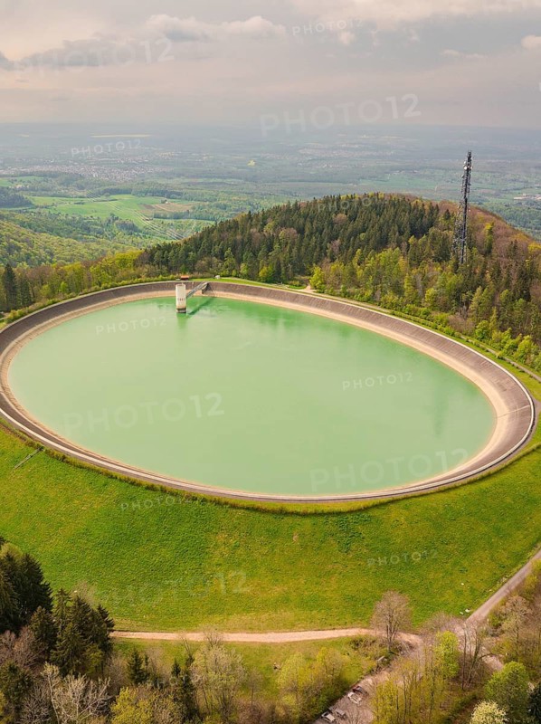 Upper reservoir, circular water reservoir in a wooded and hilly environment, Glems reservoir, Swabian Alb, Germany
