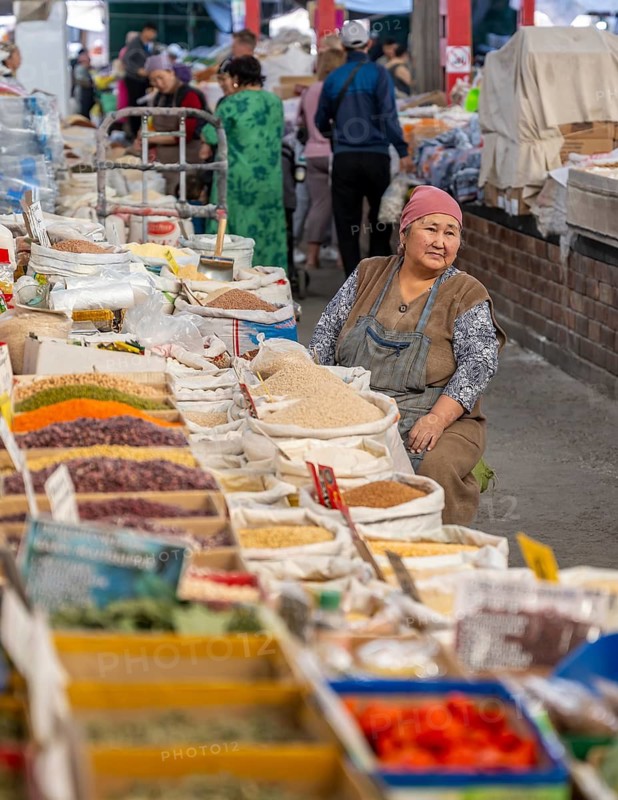 Traditional woman selling spices, flour and food, market stall at Osh Bazaar, Bishkek, Kyrgyzstan