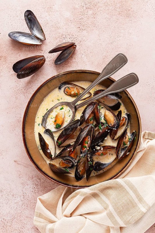 Mussels in creamy garlic sauce, served with fresh herbs and spices, homemade, no people