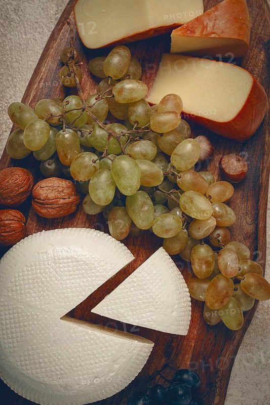 Georgian cheese, Imeretian and smoked suluguni, grapes, nuts, on a cutting board, Georgian cuisine, no people