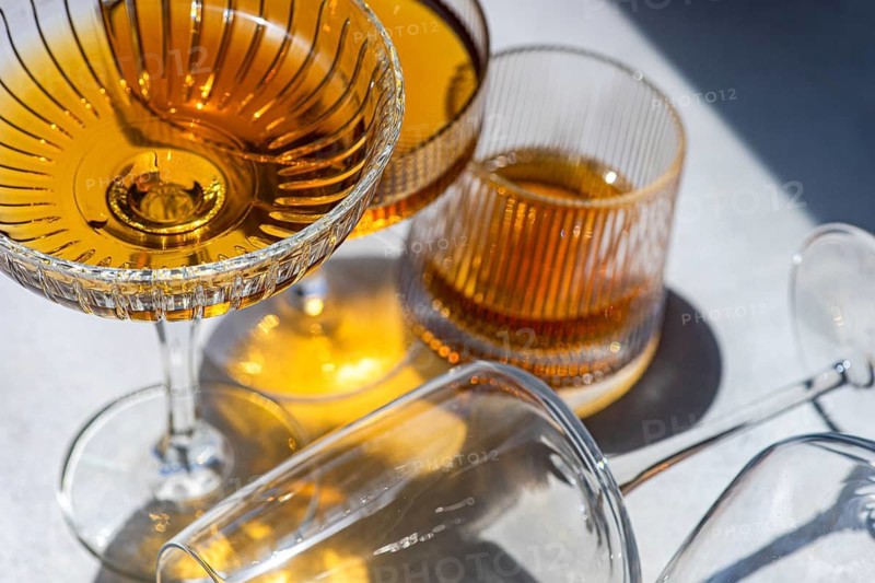 Rich hues of Georgian amber wine showcased in elegant glassware. Bathed in sunlight, the glasses reveal the intricate textures and vibrant color of this traditional wine