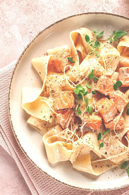 Tagliatelli pasta, with salmon slices and herbs, on a decorative plate, homemade, no people