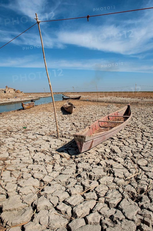Traditional Iraqi marsh dwellers canoe abandoned on the dry cracked earth of the central marshes of southern Iraq during a drought