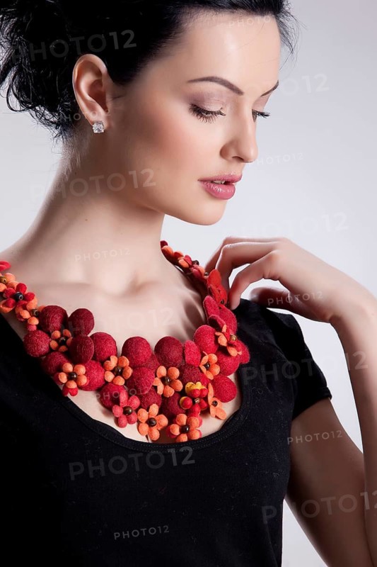 Young attractive woman dressed in fashionable handmade clothing on isolated background