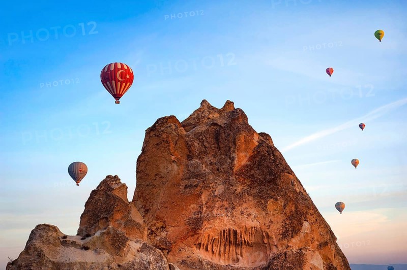 Cappadocia, Turkey. September 19th 2018 Amazing rock formation of the Anatolian landscape with hot air balloons rising against a dawn sun lit sky, Goreme, Turkey