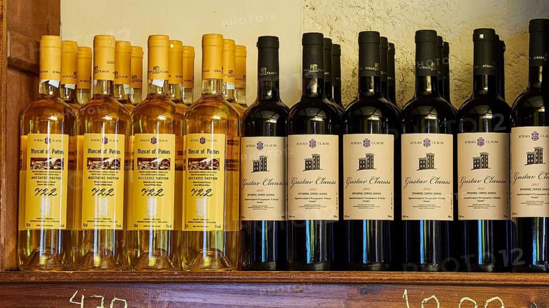 A rack with various wine bottles, yellow and black labels visible, Achaia Clauss winery, Patras, Peloponnese, Greece